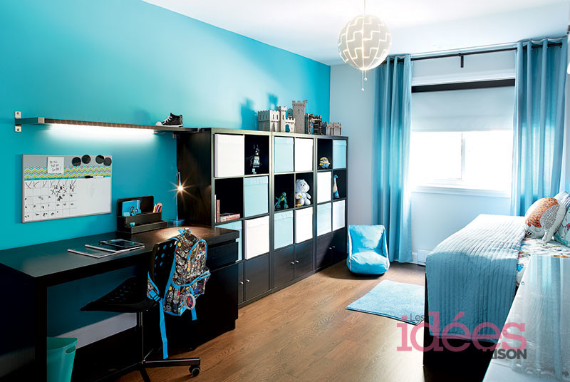 Exemple d'une chambre d'enfant de 4 à 10 ans exotique de taille moyenne avec un mur bleu, parquet foncé et un sol marron.