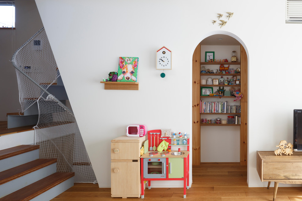 Idéer för ett modernt barnrum kombinerat med lekrum, med vita väggar, ljust trägolv och beiget golv