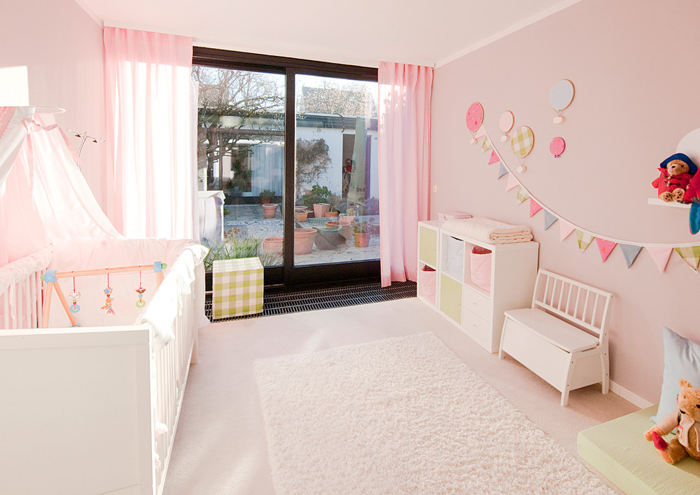 Immagine di una cameretta per bambini da 1 a 3 anni minimal di medie dimensioni con moquette e pareti rosa