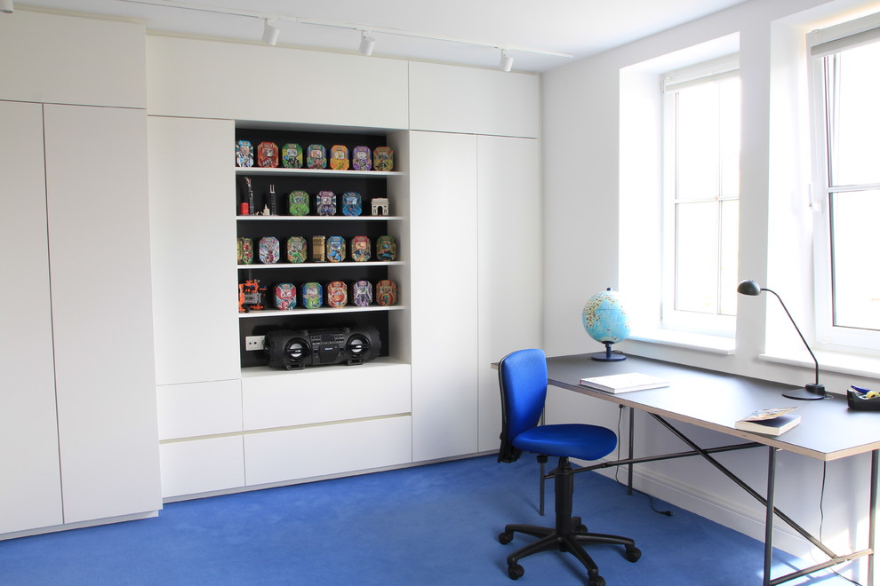 Inspiration för mellanstora moderna barnrum kombinerat med skrivbord, med vita väggar, heltäckningsmatta och blått golv
