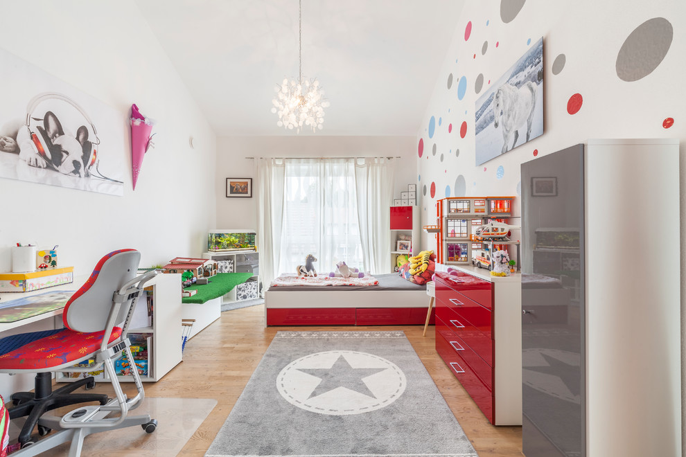 Large contemporary children’s room for girls in Other with white walls, light hardwood flooring and beige floors.