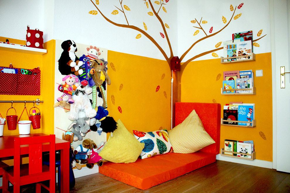 На фото: нейтральная детская с игровой среднего размера в современном стиле с разноцветными стенами для ребенка от 1 до 3 лет