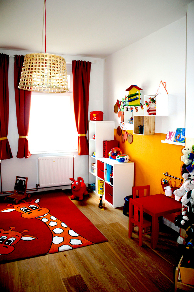 Mittelgroßes, Neutrales Modernes Kinderzimmer mit Spielecke, bunten Wänden, Laminat und braunem Boden in Berlin