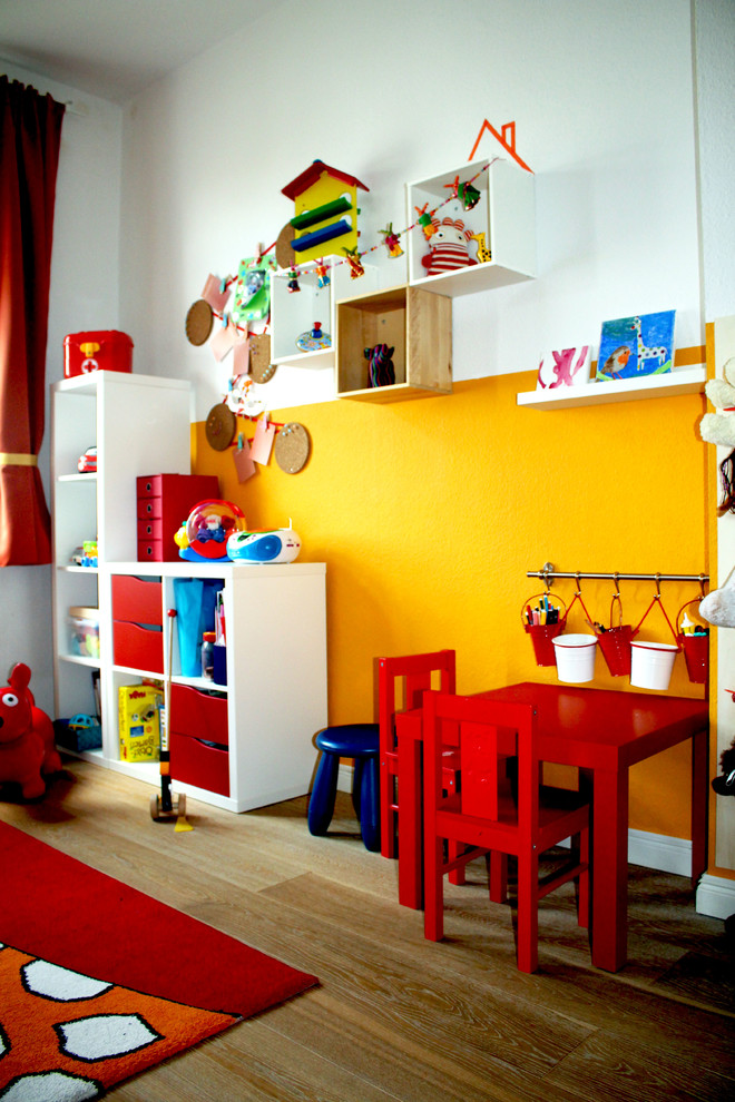 Idee per una cameretta per bambini da 1 a 3 anni design di medie dimensioni con pareti multicolore, pavimento in laminato e pavimento marrone