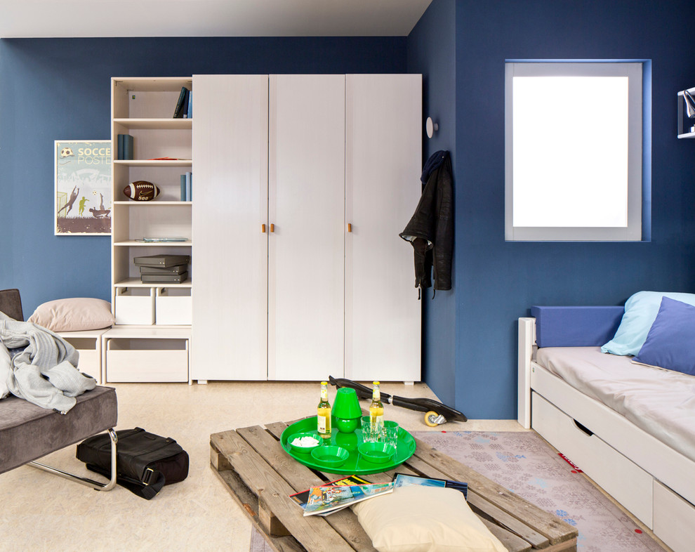 Cette photo montre une chambre d'enfant tendance avec un mur bleu et parquet clair.