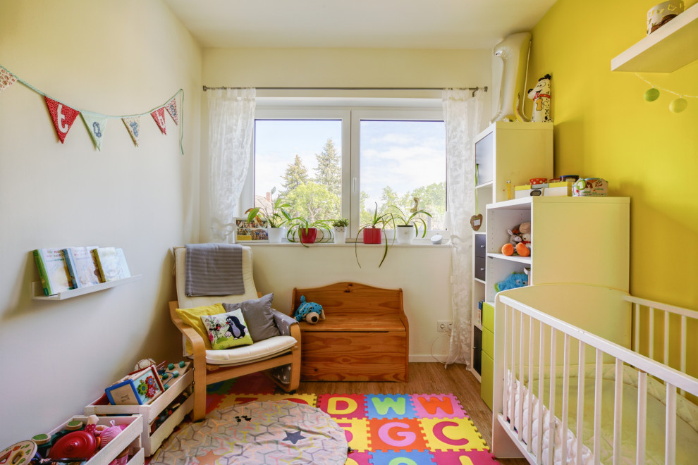 На фото: детская с игровой среднего размера в современном стиле с желтыми стенами, полом из винила, разноцветным полом и потолком с обоями для ребенка от 1 до 3 лет, девочки с