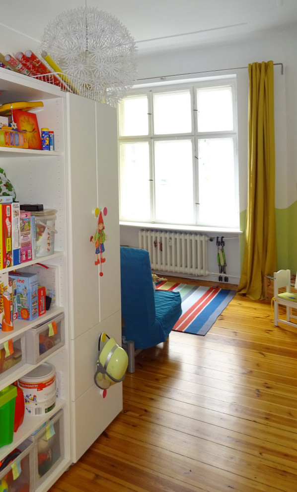 Idee per una cameretta per bambini da 1 a 3 anni contemporanea di medie dimensioni con pareti verdi, parquet scuro e pavimento marrone