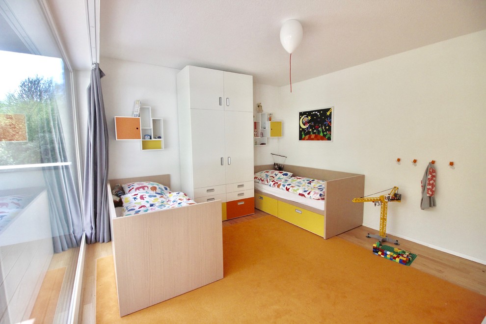 Inredning av ett modernt stort könsneutralt barnrum kombinerat med sovrum och för 4-10-åringar, med vita väggar, linoleumgolv och gult golv
