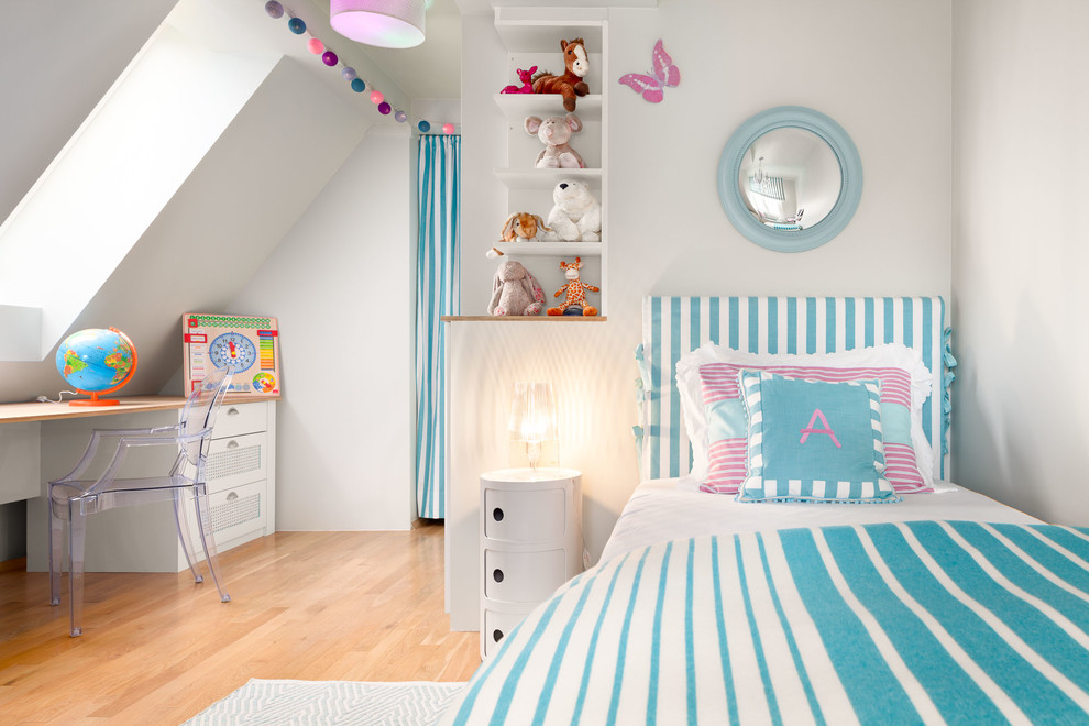 Inspiration for a small traditional children’s room for girls in Munich with light hardwood flooring, blue walls and beige floors.