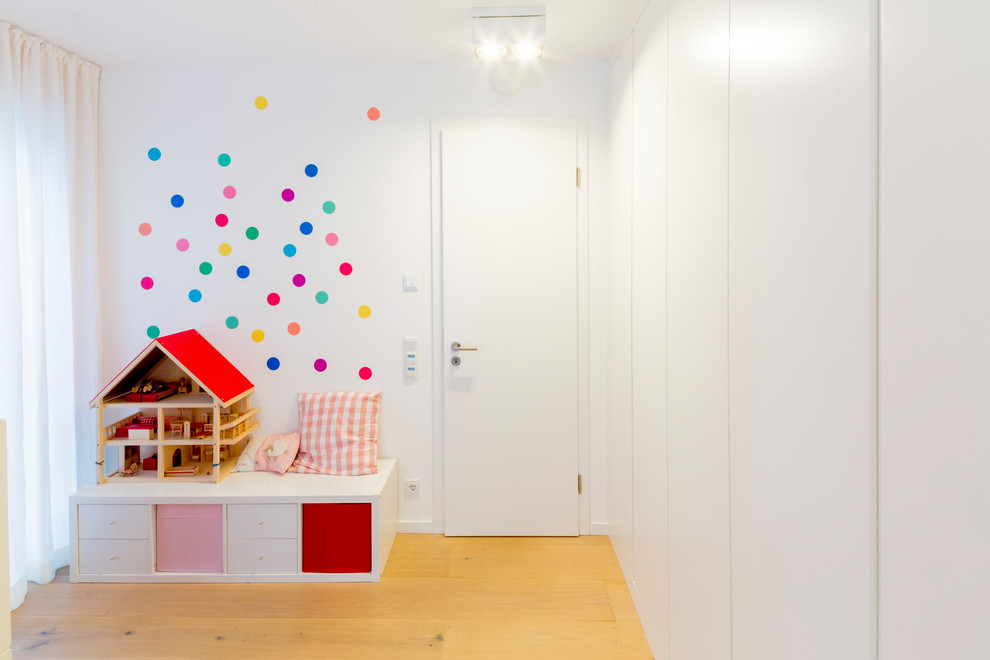 Mittelgroßes Modernes Mädchenzimmer mit Spielecke, rosa Wandfarbe, hellem Holzboden und beigem Boden in Düsseldorf