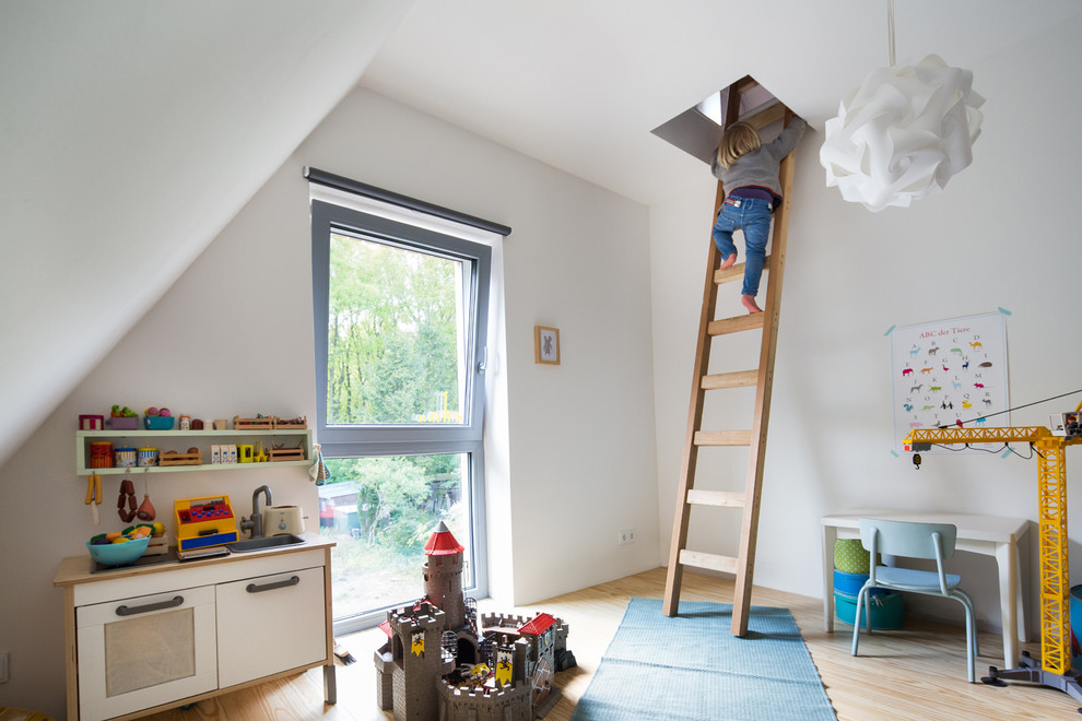 Modelo de dormitorio infantil de 4 a 10 años contemporáneo de tamaño medio con paredes blancas y suelo de madera clara