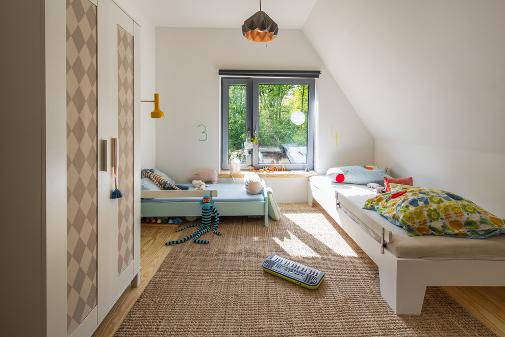 Exempel på ett mellanstort modernt könsneutralt barnrum kombinerat med sovrum och för 4-10-åringar, med vita väggar och ljust trägolv