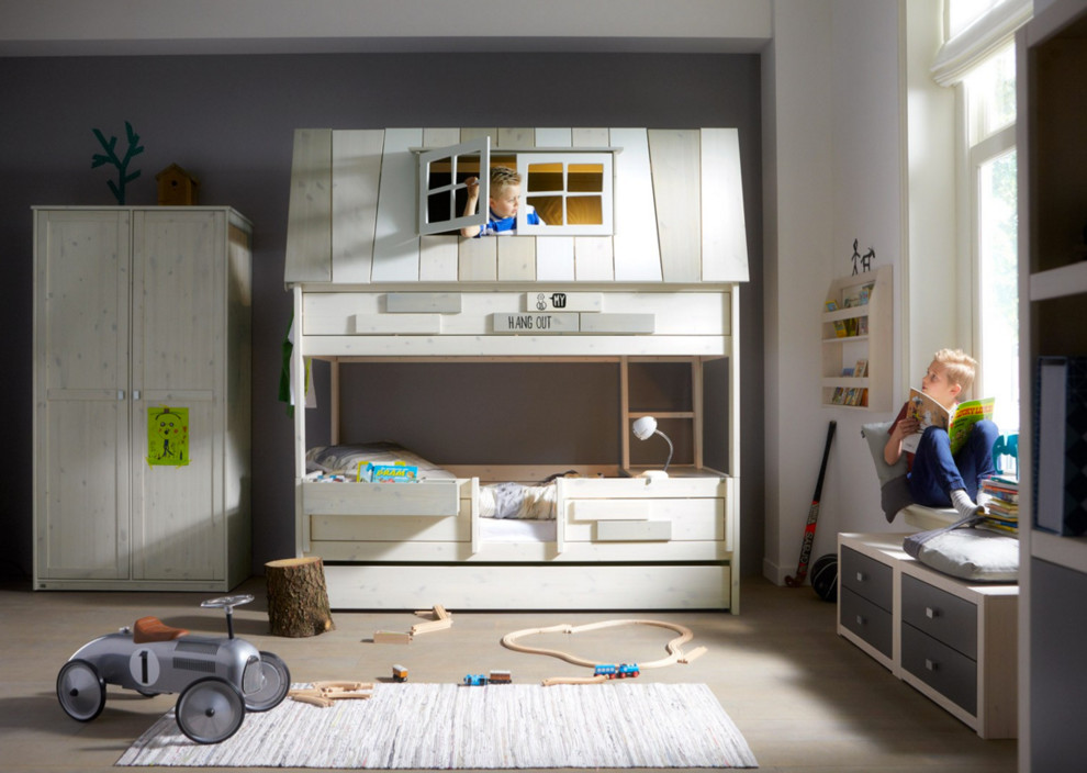 Large contemporary gender neutral children’s room in Berlin with grey walls and light hardwood flooring.