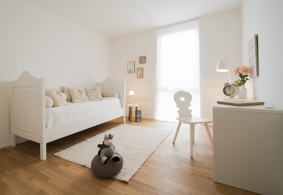 Example of a large trendy girl medium tone wood floor kids' room design in Essen with white walls