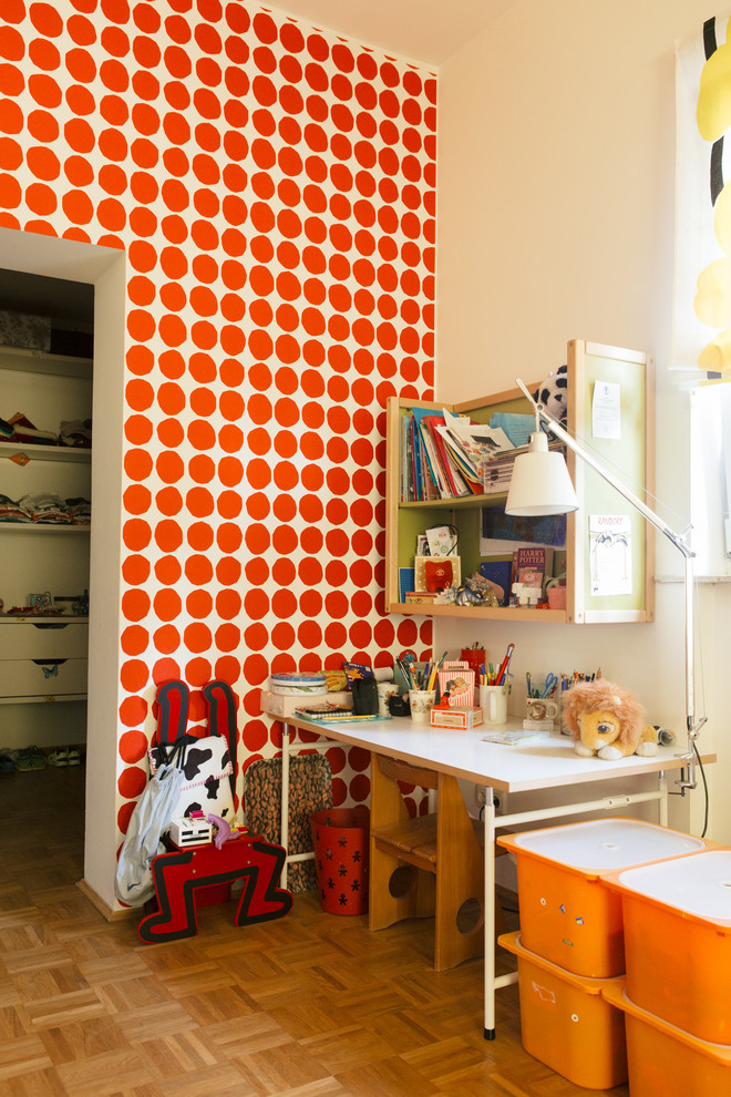 Imagen de habitación infantil unisex bohemia de tamaño medio con escritorio, suelo de madera en tonos medios y paredes multicolor