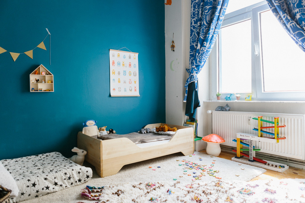 Modelo de habitación infantil unisex bohemia de tamaño medio con paredes azules y moqueta