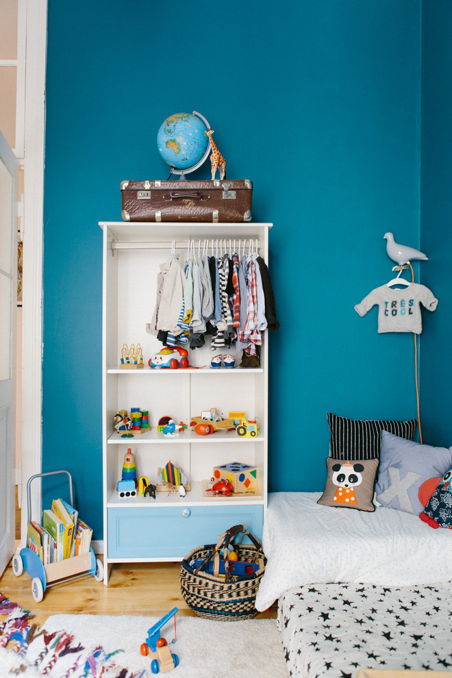 Foto de habitación de niño bohemia de tamaño medio con paredes azules y suelo de madera clara