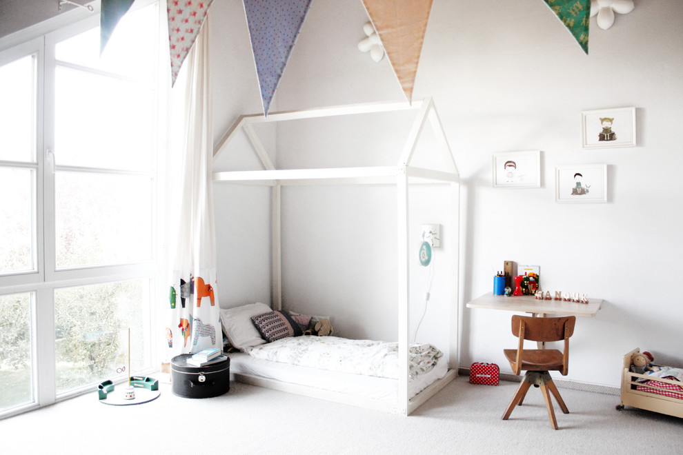Nordisk inredning av ett mellanstort könsneutralt barnrum kombinerat med sovrum och för 4-10-åringar, med vita väggar och heltäckningsmatta