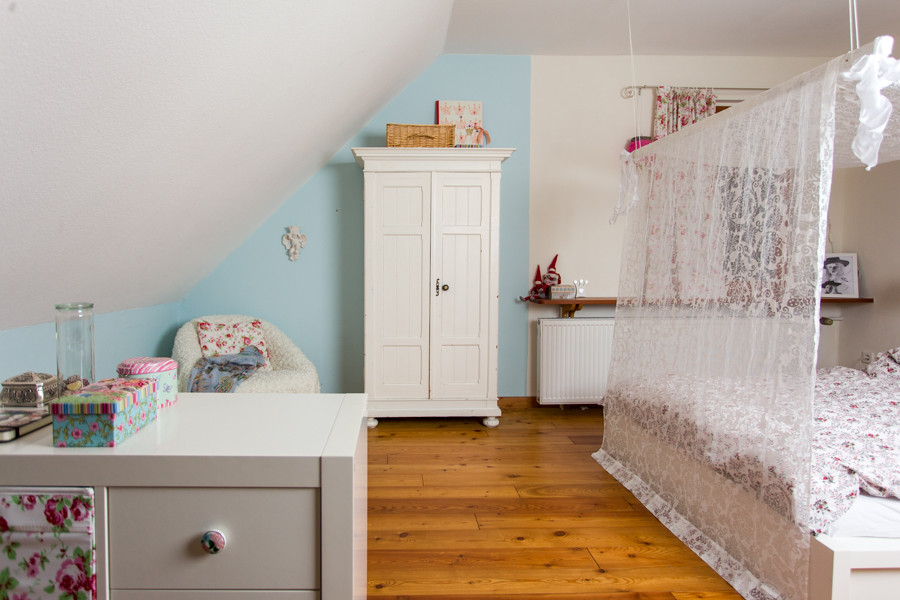 Inredning av ett modernt mellanstort barnrum kombinerat med sovrum, med blå väggar och ljust trägolv