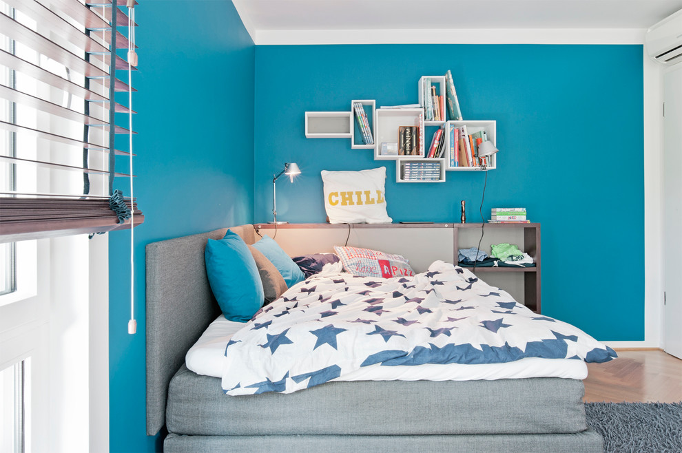 Diseño de dormitorio infantil contemporáneo extra grande con paredes azules, suelo de madera en tonos medios y suelo marrón