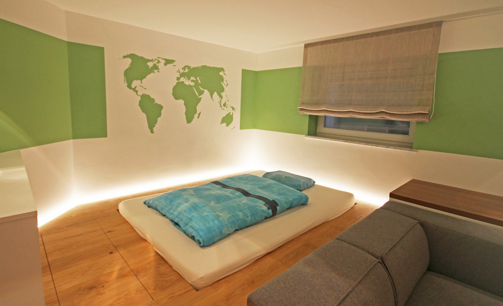 Inspiration för stora moderna barnrum kombinerat med sovrum, med gröna väggar, ljust trägolv och brunt golv