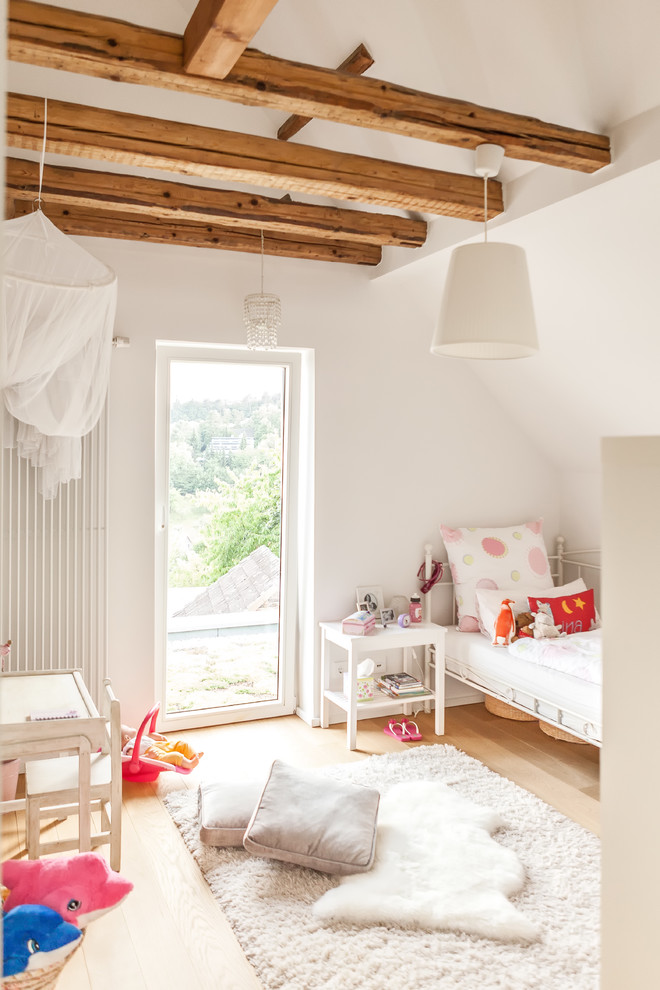 Inspiration för ett stort lantligt flickrum kombinerat med sovrum och för 4-10-åringar, med vita väggar, ljust trägolv och brunt golv