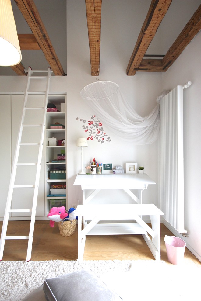 Aménagement d'une petite chambre de fille de 4 à 10 ans campagne avec un bureau, un mur blanc, parquet clair et un sol marron.