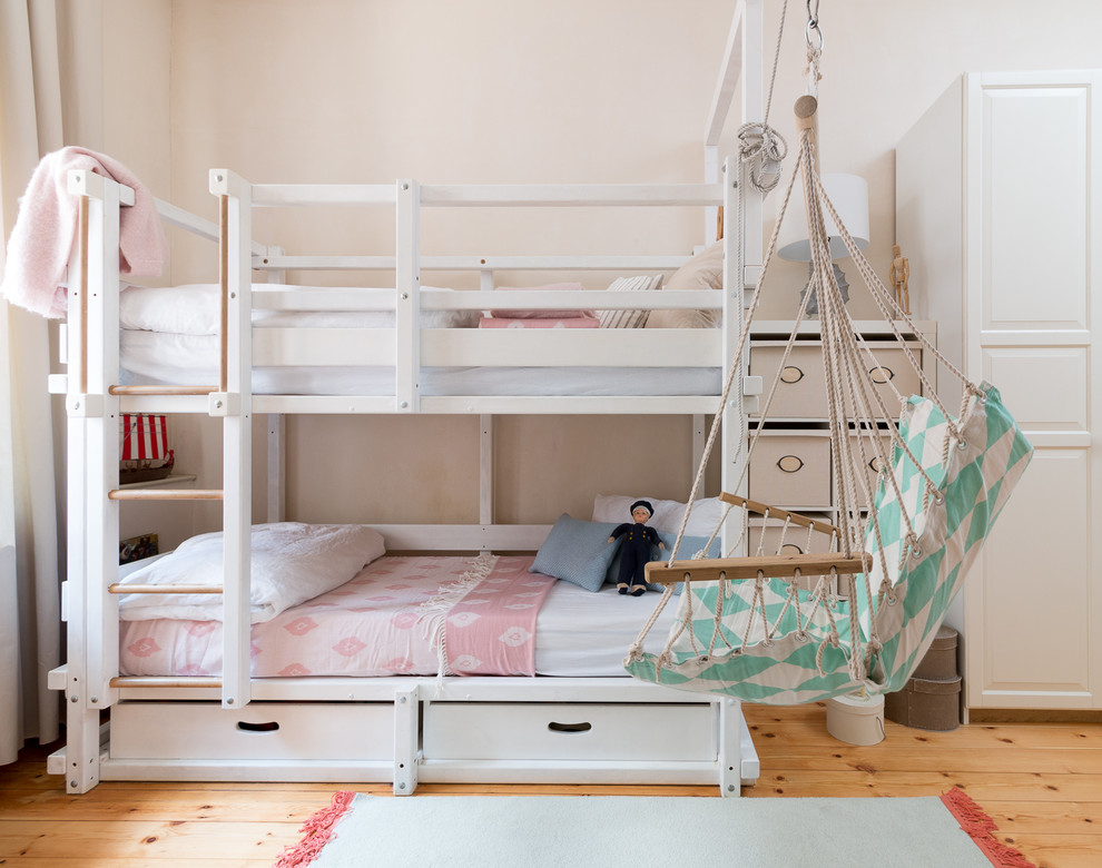 Cette image montre une petite chambre d'enfant de 4 à 10 ans marine avec un mur rose, un sol en bois brun, un sol marron et un lit superposé.