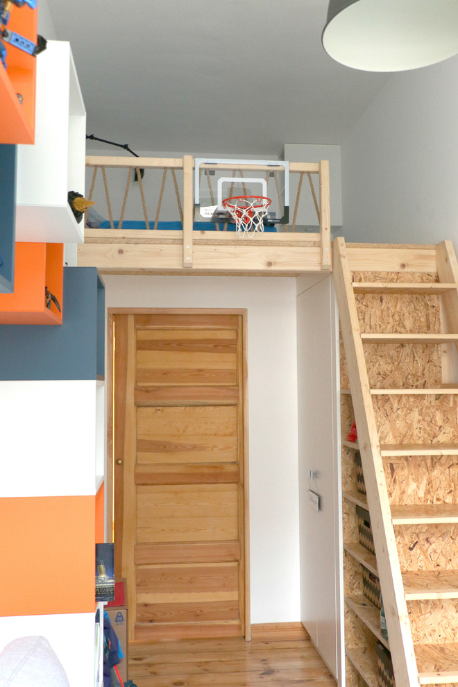 Mittelgroßes Modernes Kinderzimmer mit Schlafplatz, weißer Wandfarbe und hellem Holzboden in Berlin