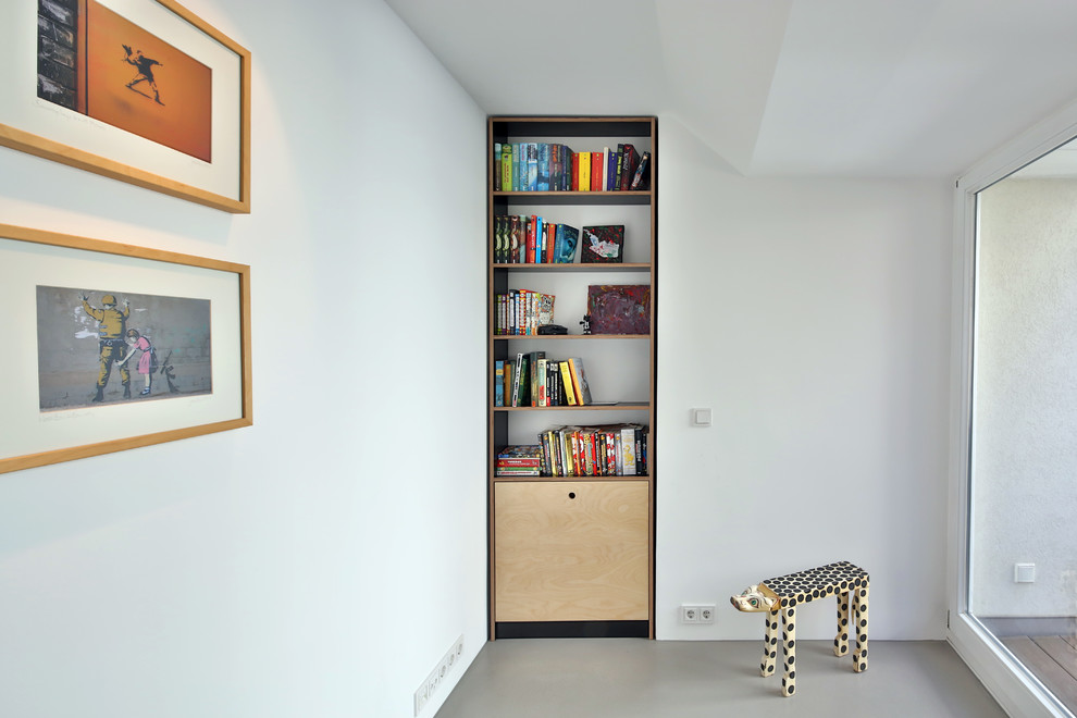 Cette image montre une petite chambre d'enfant design avec un mur blanc, un sol gris, un bureau et sol en béton ciré.