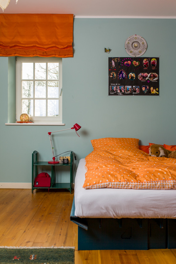 Immagine di una cameretta per bambini minimal di medie dimensioni con pareti blu e parquet chiaro