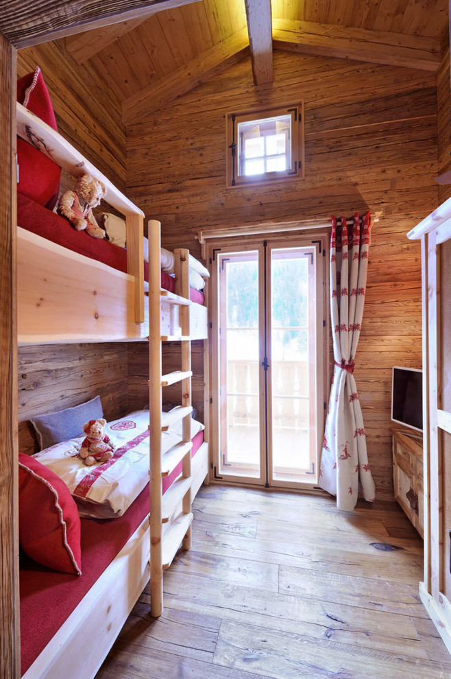 Rustic gender neutral children’s room in Other with beige walls and light hardwood flooring.