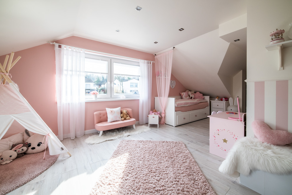 Inspiration för mellanstora moderna flickrum kombinerat med lekrum och för 4-10-åringar, med rosa väggar, laminatgolv och beiget golv