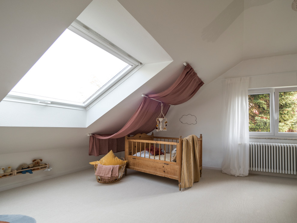 This is an example of a medium sized toddler’s room for girls in Munich with white walls, carpet and beige floors.