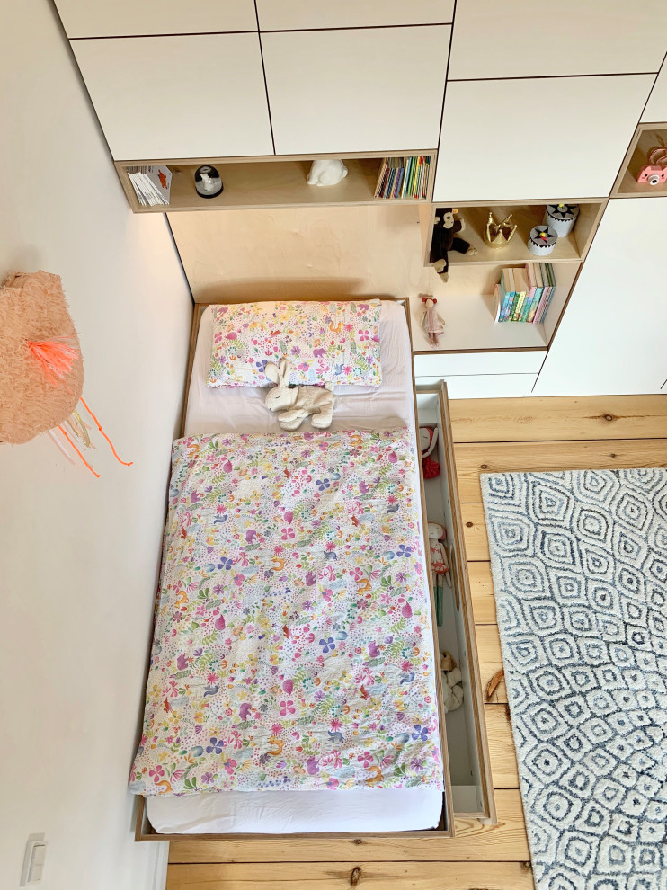 Foto på ett mellanstort funkis flickrum kombinerat med lekrum och för 4-10-åringar, med vita väggar, ljust trägolv och brunt golv