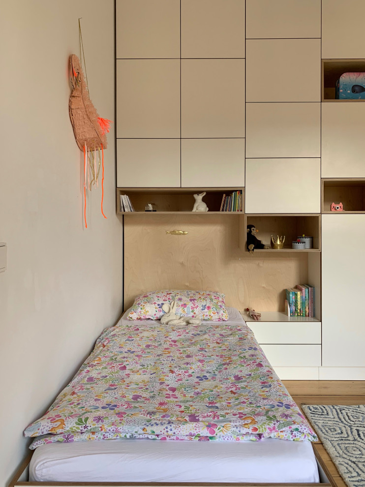 Inspiration pour une chambre d'enfant de 4 à 10 ans design de taille moyenne avec un mur blanc, parquet clair et un sol marron.