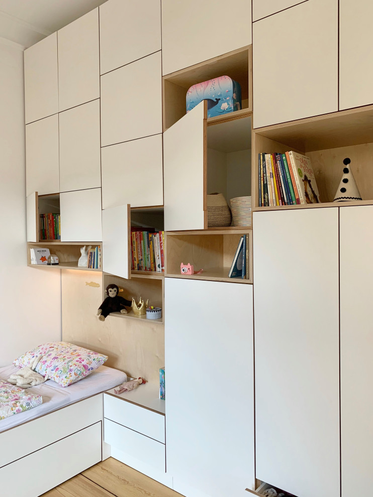 Idee per una cameretta per bambini da 4 a 10 anni contemporanea di medie dimensioni con pareti bianche, parquet chiaro e pavimento marrone