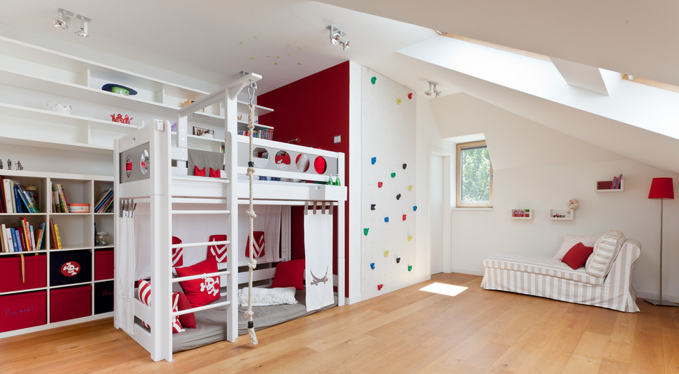Foto på ett stort funkis könsneutralt barnrum kombinerat med lekrum och för 4-10-åringar, med vita väggar och mellanmörkt trägolv