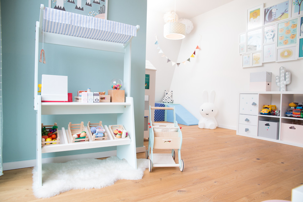 Inredning av ett skandinaviskt mellanstort könsneutralt småbarnsrum kombinerat med lekrum, med vita väggar, mellanmörkt trägolv och beiget golv