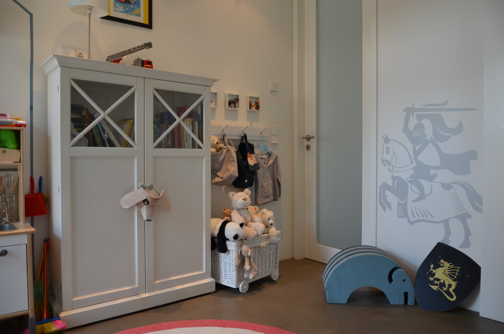 Immagine di una piccola cameretta per bambini da 4 a 10 anni contemporanea con pareti bianche, pavimento in cemento e pavimento grigio