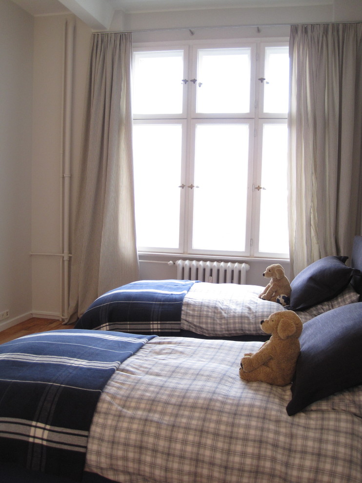 Foto de dormitorio infantil actual con paredes blancas y suelo de madera en tonos medios
