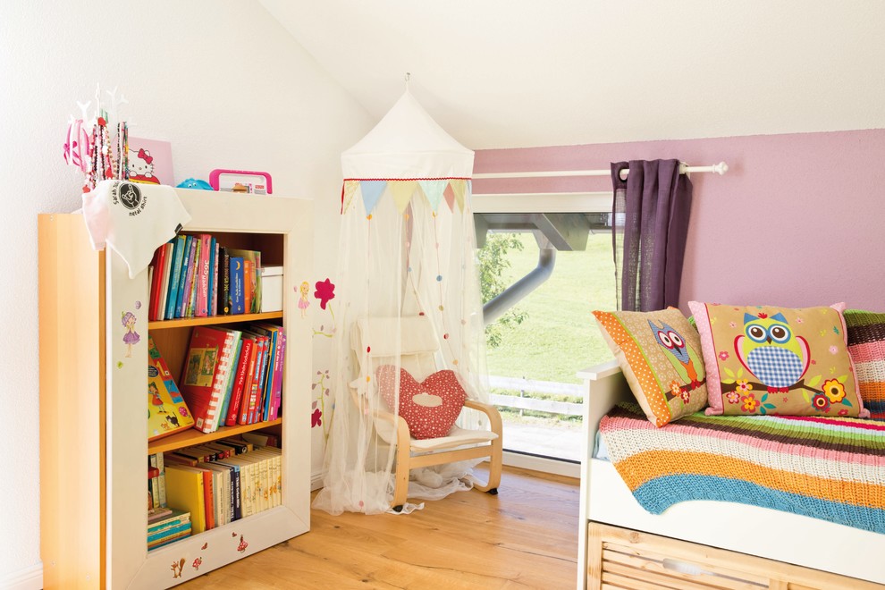 Landhausstil Mädchenzimmer mit rosa Wandfarbe, gebeiztem Holzboden und braunem Boden in Sonstige