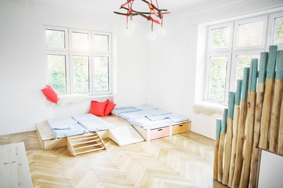 Immagine di una grande cameretta per bambini da 4 a 10 anni design con pareti bianche e pavimento in legno massello medio