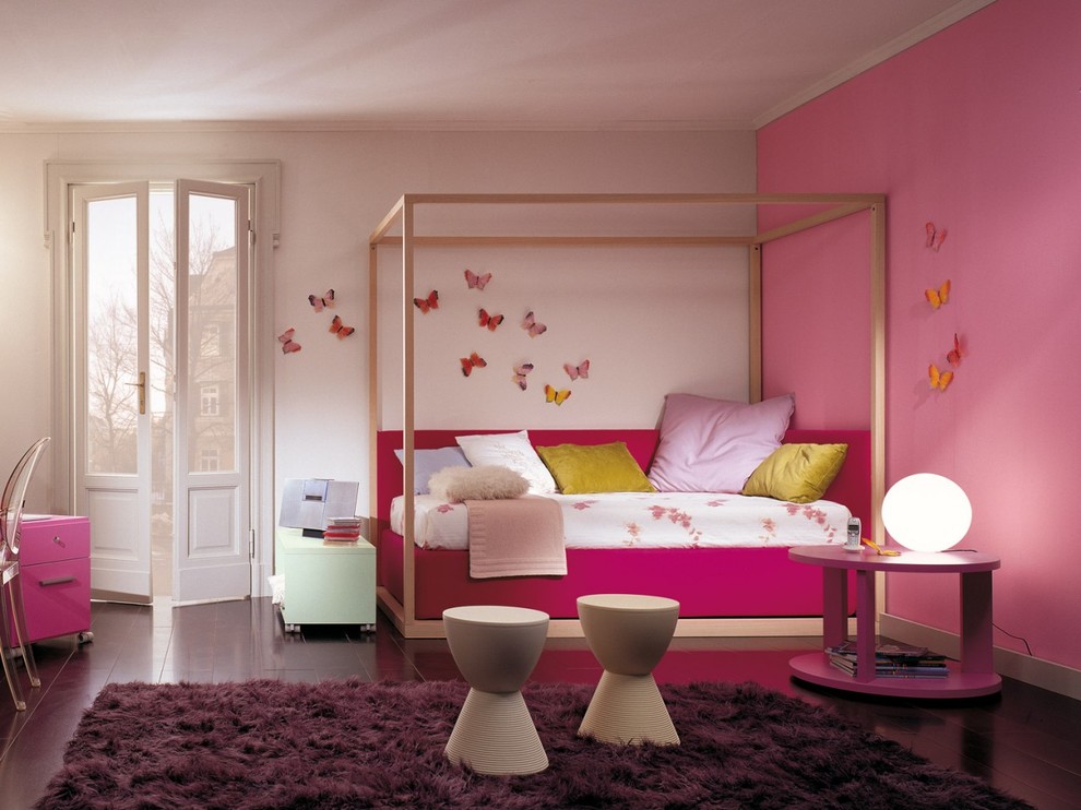 Idée de décoration pour une grande chambre d'enfant de 4 à 10 ans design avec un mur rose, parquet foncé et un sol violet.
