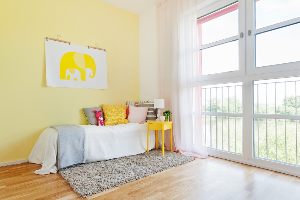 Imagen de dormitorio infantil de 4 a 10 años contemporáneo grande con suelo de madera en tonos medios y paredes multicolor