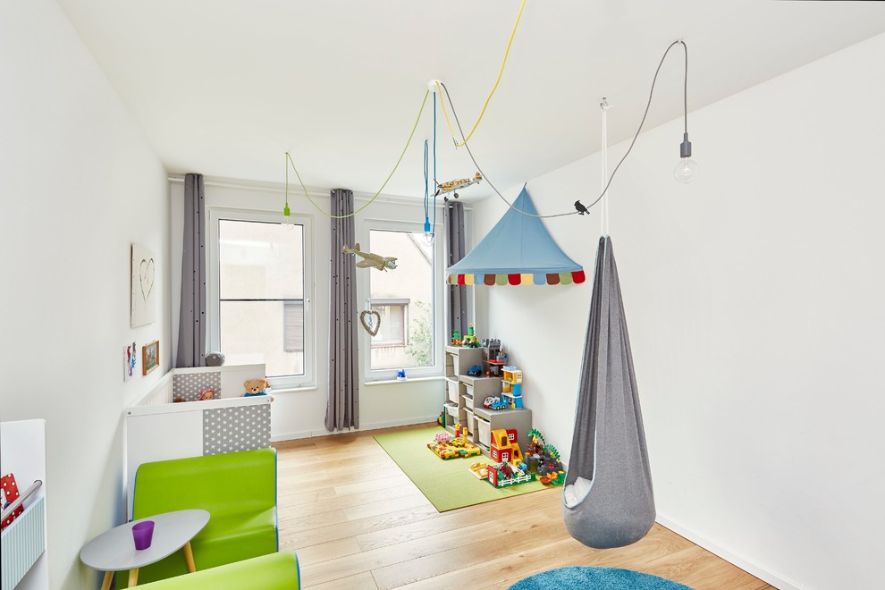 Idées déco pour une chambre de garçon de 1 à 3 ans scandinave de taille moyenne avec un mur blanc, parquet clair et un sol beige.
