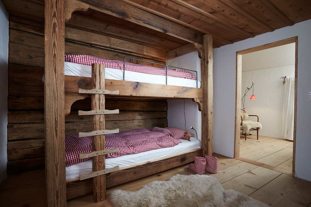 Rustikales Kinderzimmer mit Schlafplatz, weißer Wandfarbe und braunem Holzboden in Sonstige
