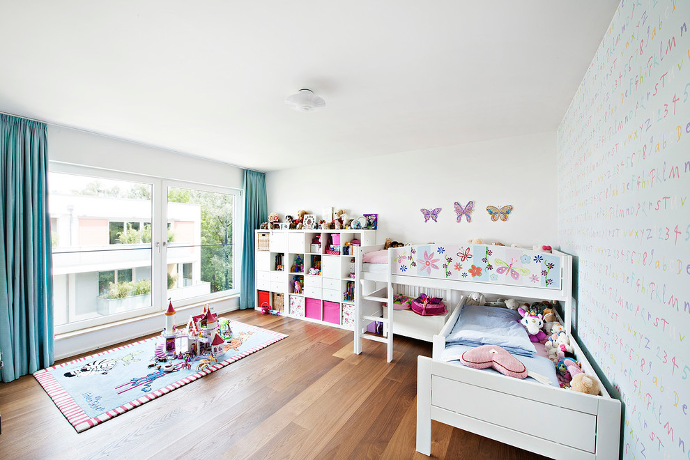 Bild på ett stort funkis flickrum kombinerat med sovrum och för 4-10-åringar, med vita väggar och mörkt trägolv