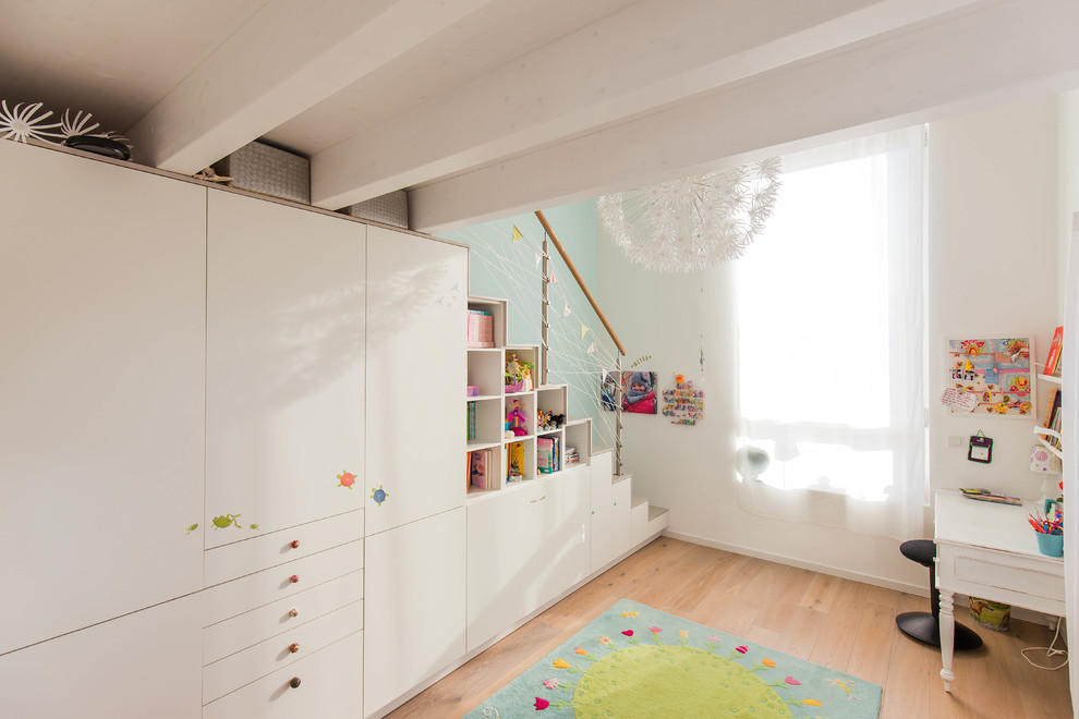 Ejemplo de habitación de niña actual con suelo de madera clara