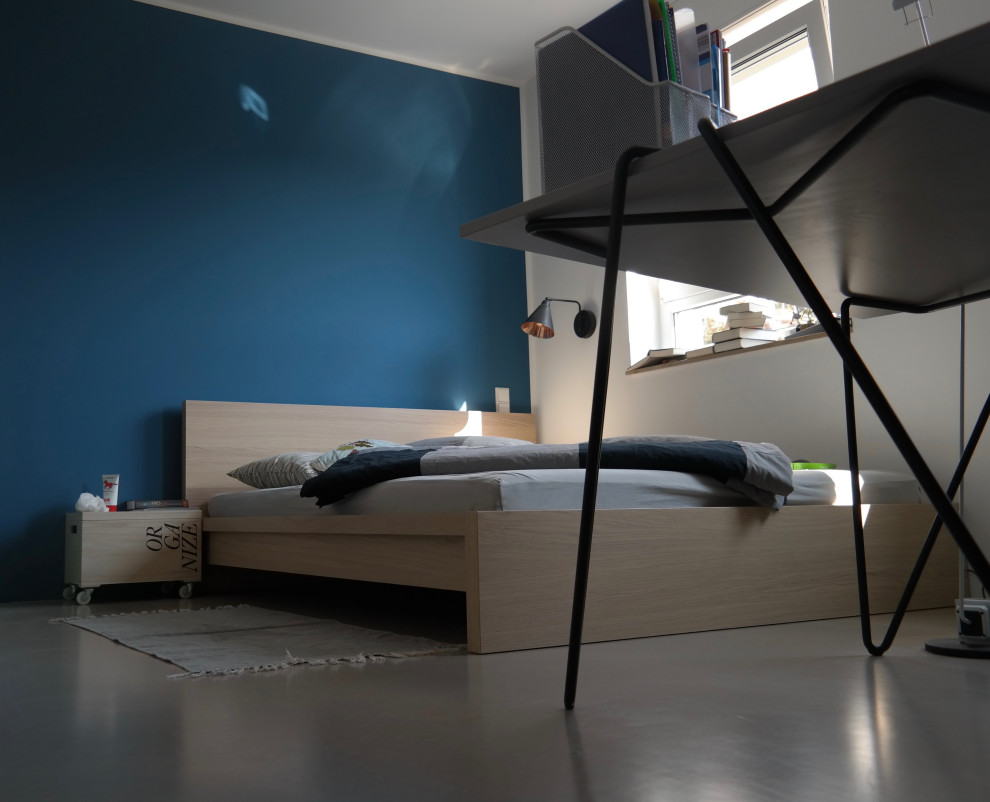 Bild på ett mellanstort funkis barnrum kombinerat med sovrum, med blå väggar, betonggolv och grått golv